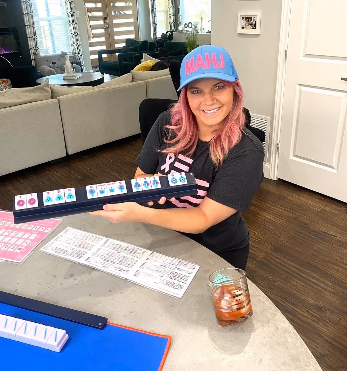 Courtney at the table mid-game, the mahjong card and colorful tiles laid out in front of her