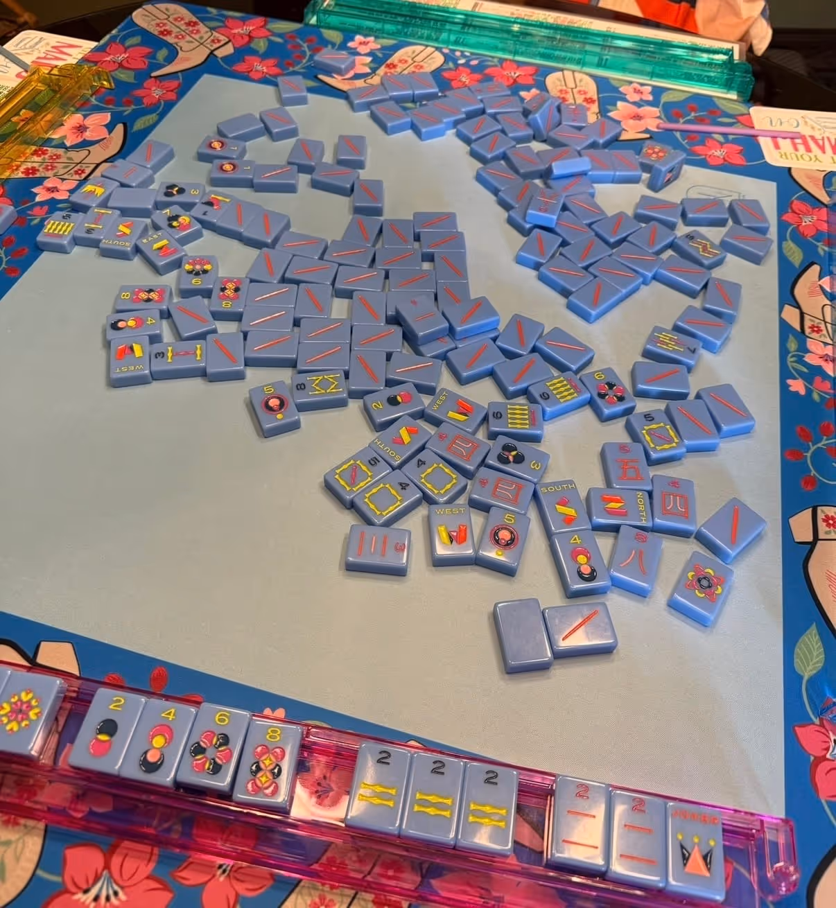 A mahjong table set up at home: mat, racks, tiles and the American mahjong card, ready to play