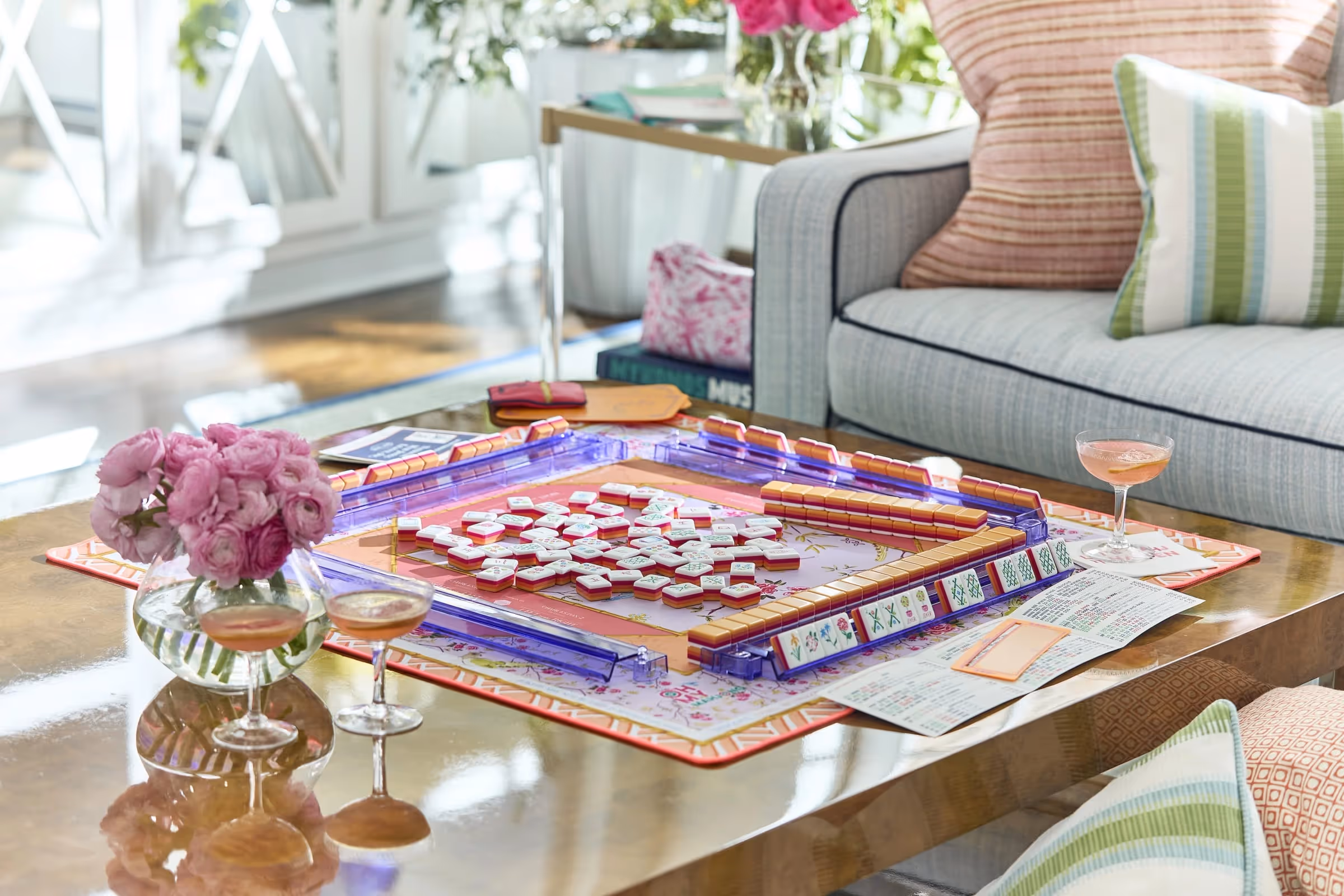 A game of American mahjong in play around a table, tiles and racks set out