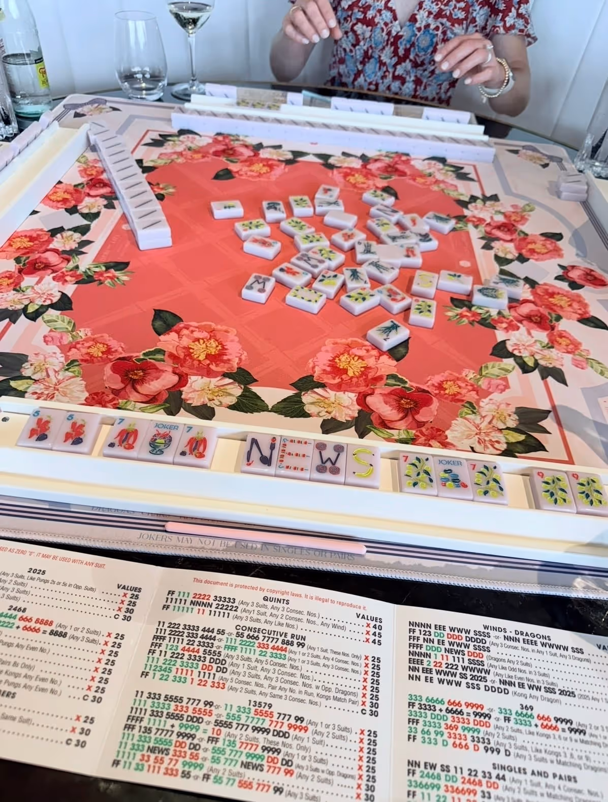 American mahjong tiles lined up along a rack on a bright playing mat